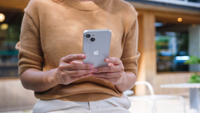 May 22th 2023 : A woman holding and using Iphone 13 smart phone, Chiang mai Thailand