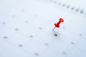 Red pin on the 15th day on the calendar. Business planning concept.