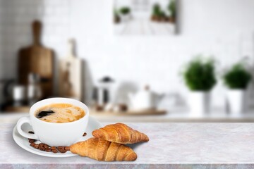 Cup of hot coffee and fresh croissant