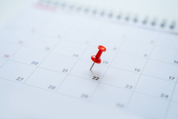 Close up Pin on the date number 22 of the month is marked with a red thumbtack selective focus.