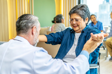 Obraz premium Happy patient and doctor, rehabilitation after injuries, male physiotherapist raising hands of active senior woman in hospital, Musculoskeletal Pain Therapy and Rehabilitation Concept for Senior