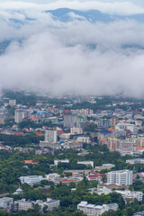 Fog covers the city and houses. A beautiful aerial view of Chiang Mai Thailand with sea fog covering the building, airport and parts of the city. Revealing part of the business building and road