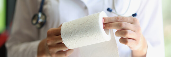 Female doctor hands demonstrates toilet paper roll