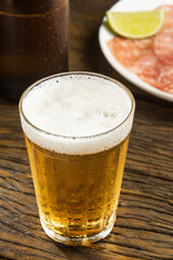Pouring beer from can into glass on table, closeup