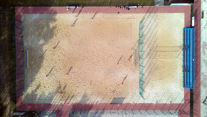 Aerial top down view of a football and valley court on the beach sand in the resort. © Robert