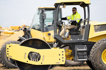 construction machinery worker at roller. machinery in a manufacturing industry with construction worker outdoor. construction worker used heavy machinery. construction industry with machinery worker