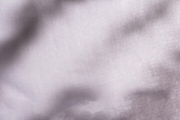 Obraz premium Blur shadow of leaves on white fabric. white cloth background soft wrinkled fabric pattern and surface