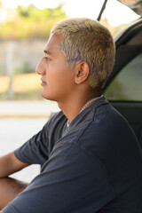 Fototapeta premium Young man sitting in car
