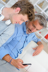 Fototapeta premium Teenager looking at father using cellphone