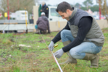 surveyor worker making measurement in the garden