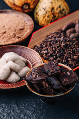 Cocoa beans and cocoa pod on a wooden surface.