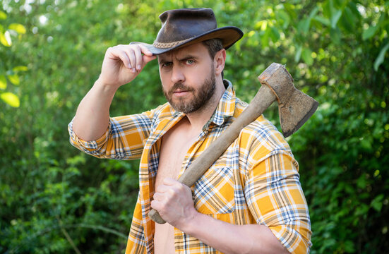 image of cowboy with axe. cowboy with axe. cowboy with axe wearing checkered shirt.