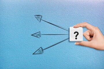 Human hand hold a wooden cube with arrows