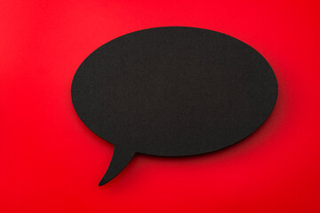 Black Cardboard Cutout of Blank Speech Bubble on Red Background with Copy Space: Concept for...