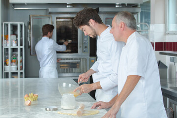 young man learns to bake cakes with porfessionalnym baker