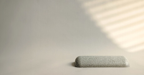 Minimal round stone product display with sunlight from window on cream color background