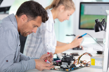 people repairing a computer in a workshop