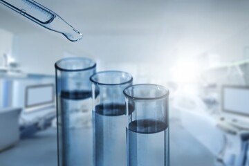 Dripping liquid from glass pipette in laboratory,