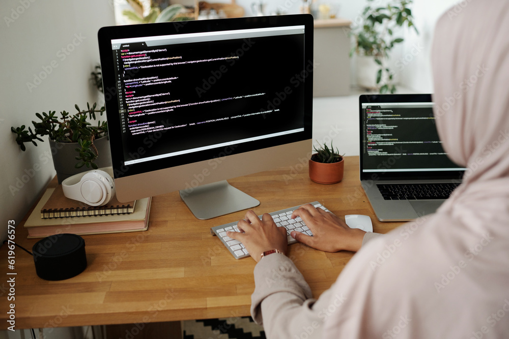 Poster Hands of young Muslim female IT engineer typing on computer keyboard while sitting by workplace in front of screen and decoding data
