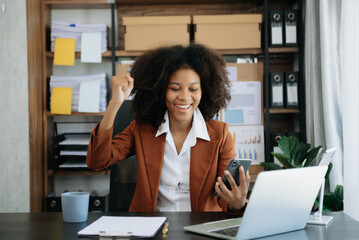 African business woman are delighted and happy with the work they do on their tablet, laptop and taking notes at office.