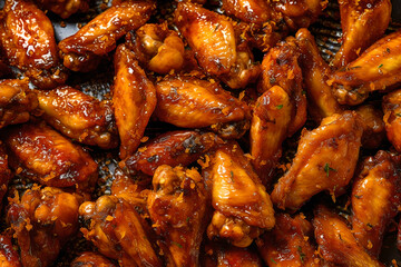 Crispy chicken wings fullframe background. Roasted chicken wings in barbecue sauce. Top view