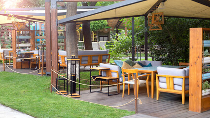 Summer street cafe in the morning sunrise interior in green city park, ornate with flowers and decorative elements, cozy place for outdoor coffee or diner