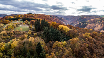 fall autumn aerial view rock with medieval castle Ehrenburg on it near moselle river in Brodenbach with forest hills - obrazy, fototapety, plakaty