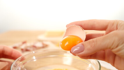 Female hands throw out the yolk from the shell. POV. Close-up. Raw egg yolk separated inside half...