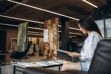 a woman looks at a catalog of goods in a hardware store