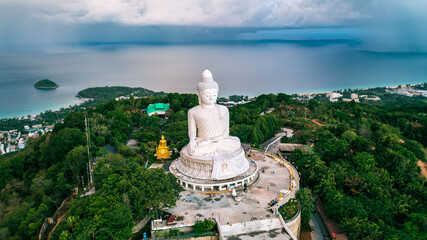 Beautiful Phuket white Big Buddha statue on blue sky background. Aerial view of Big Buddha viewpoint at sunrise in Phuket province, Thailand.