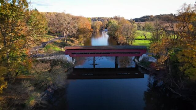 River valley covered bridge drone autumn leaves flyover
