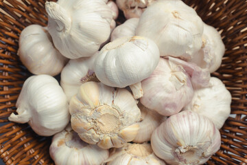 Lots of garlic in wooden basket, close-up, garlic background, top view