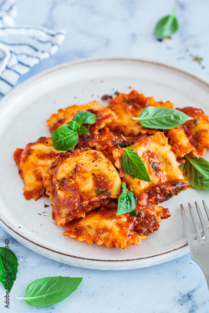 Poster Ravioli with ricotta, tomato sauce and basil, white marble background.