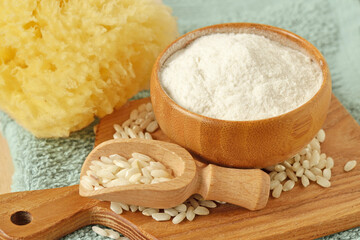 Rice flour in wooden bowl and grains of rice on wooden chopping board - Natural beauty ingredient