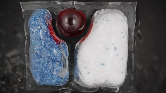 The soluble packet, dishwasher capsules with red and blue powder inside, and red gel are filled with water and they dissolve.