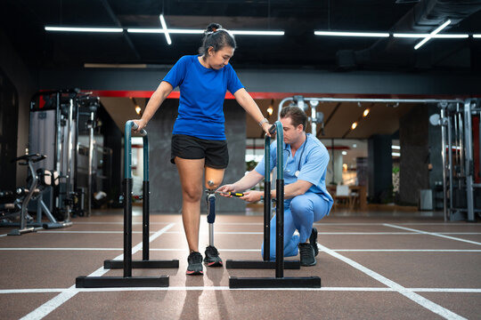 Assisted male physiotherapist take care woman with prosthetic leg and use screwdriver repair to prosthetic leg