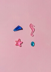 Marine transparent colorful figurines or kid's toys on the pink background. Summer sea vacation concept composition