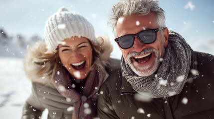 happy mature couple in winter during snow wearing winter cloths