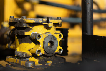 Components on a piece of heavy machinery at a construction site for a major infrastructure project. An earthmover, pallet mover, and other heavy equipment is ready to go. 