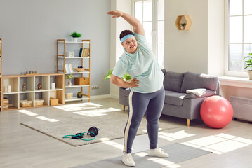 Portrait of a funny young smiling fat overweight woman wearing sportswear doing fit warming up...