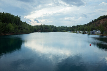 Flooded quarry with crystal clear water. Panorama of a quarry with blue water. Cloudy weather in the Polish maldives.