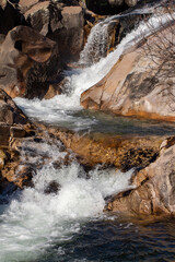 Fotografía de una cascada: Una imagen que muestra una cascada en el río de La Pedriza. El agua cae en cascada desde lo alto de una formación rocosa, creando un hermoso efecto de movimiento.