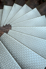 background abstract metallic stainless steel floor. Close-up of a spiral staircase lined with steel plates. metal texture