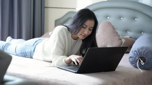 Relaxed Asian Woman Enjoying Wireless Technology in a Cozy Indoor Setting