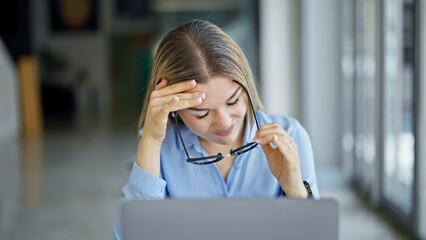 Young blonde woman business worker using laptop working stressed at office