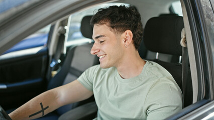 Young hispanic man smiling confident driving car at street