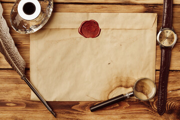 Old paper on brown wood background with feather