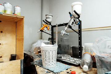 Airbrush paint gun in paint in car service station