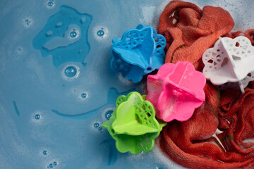 Laundry Balls, Multi-Colors In a bucket with ready-to-wash laundry, there is water and a small amount of detergent bubbles