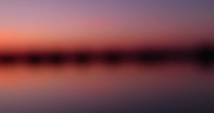 beautiful orange-yellow sunset on the lake in spring, the sun illuminates the lake with yellow-orange color at sunset